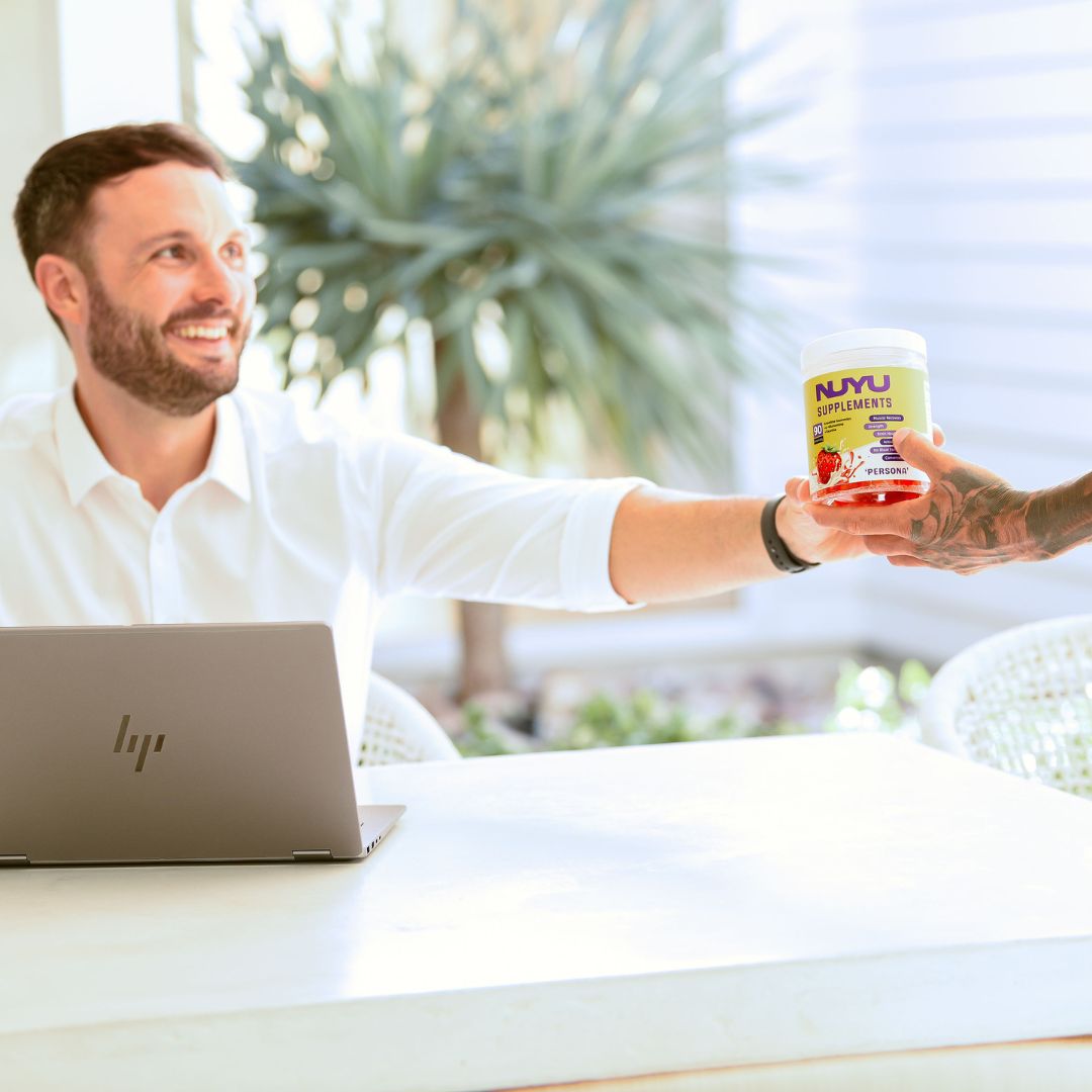 Man taking NUYU creatine gummy at his desk